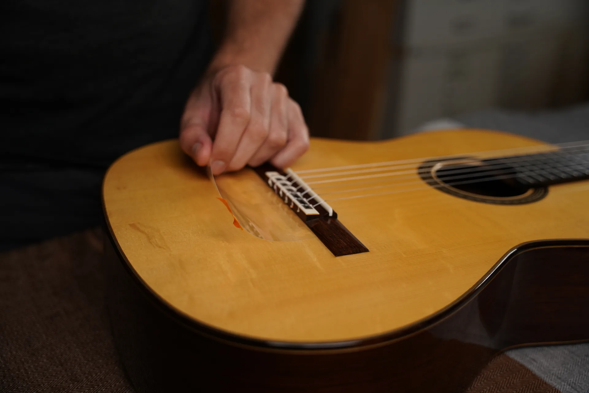 Electrostatic protective sheet placed behind the bridge to protect the soundboard varnish