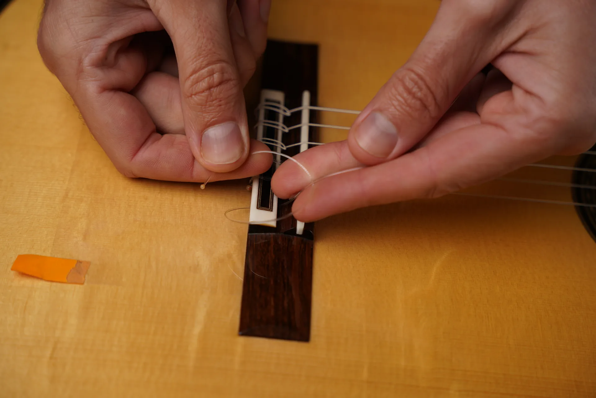 Making a loop with the treble string, as with bass strings — then adding loops depending on thickness
