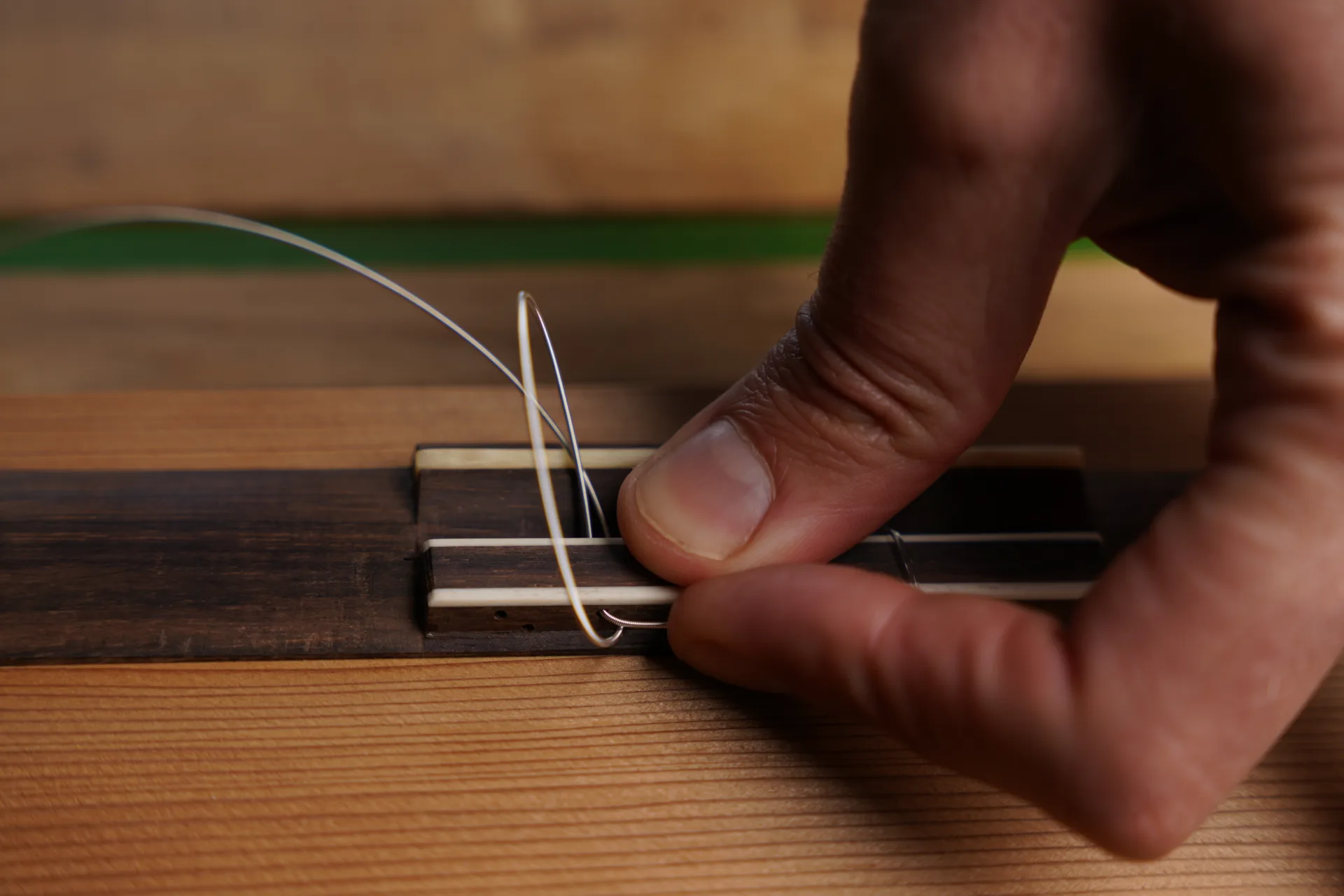 Hold the loose end in place and tighten the knot for the 12-hole bass string