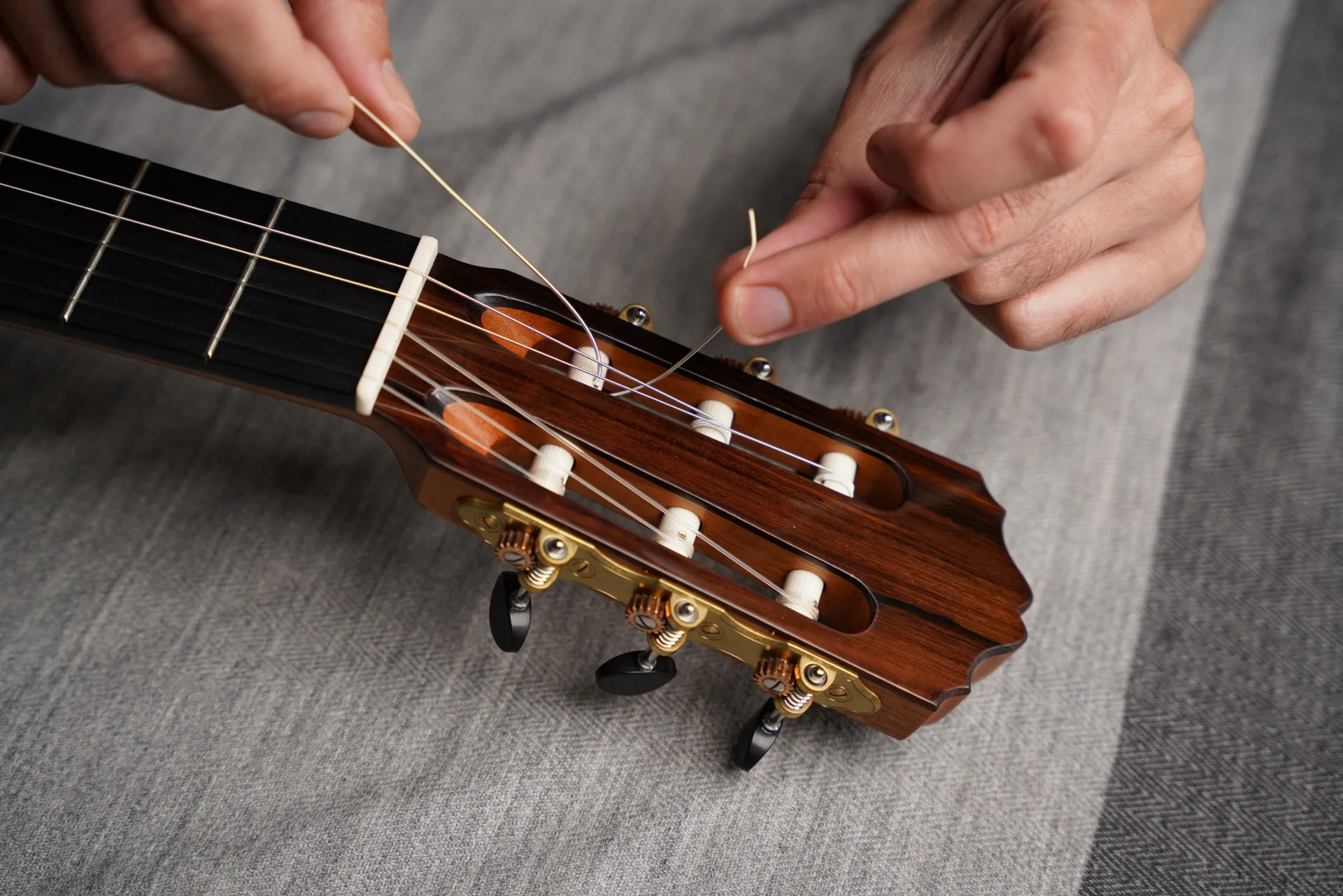 Position the tuning post hole vertically and pass the string through from top to bottom