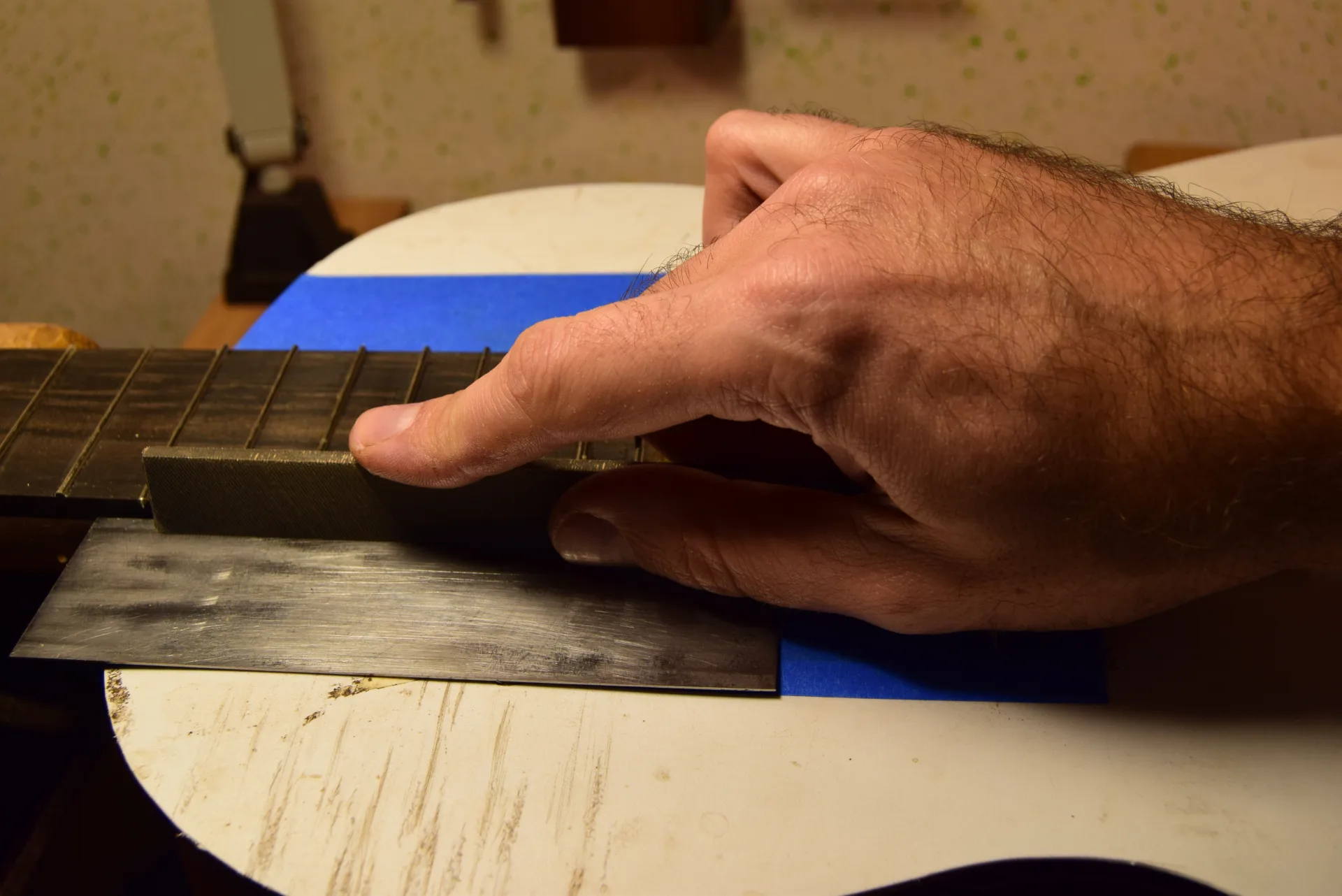 Filing along a metal guide with the soundboard carefully protected