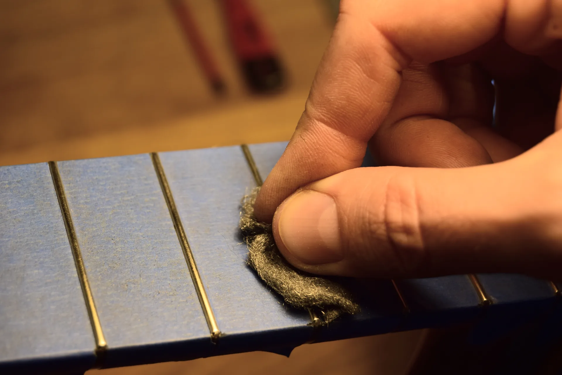 Polishing each fret with very fine steel wool