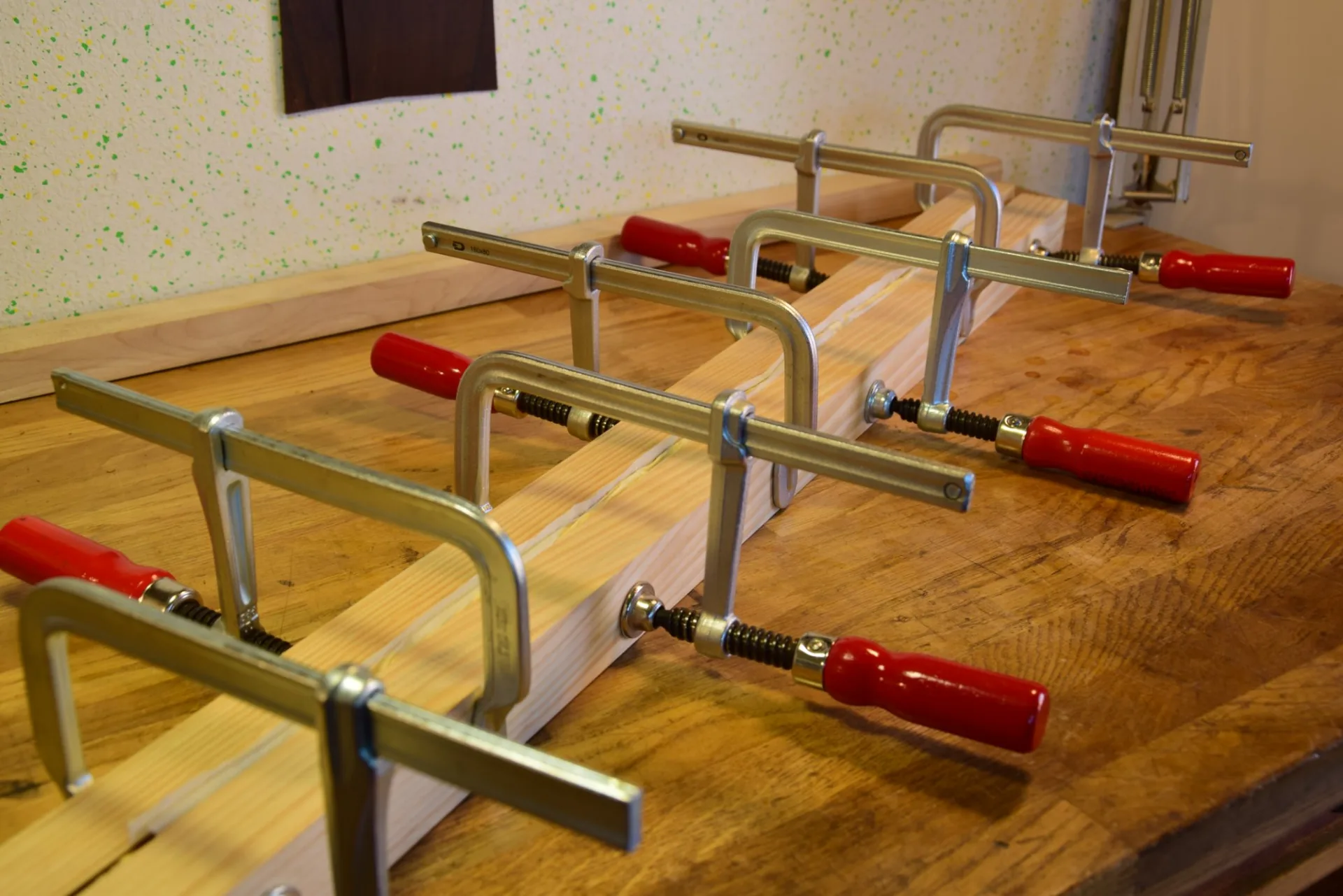 Clamping the veneer stack — pressure applied very gradually in successive passes to prevent the veneers from slipping