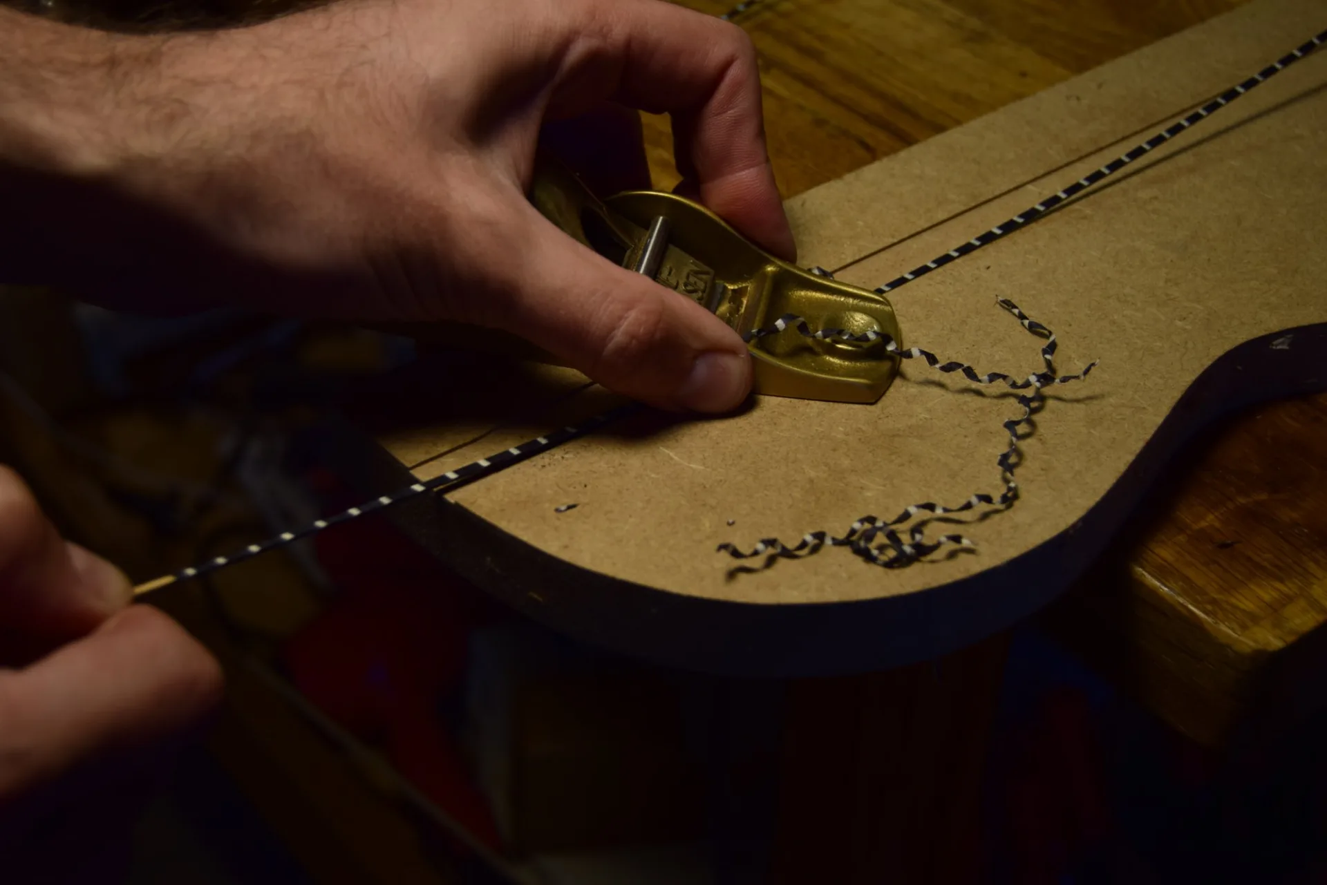 Thicknessing using a groove of the desired depth in MDF — the plane stays fixed while the hand pulls the slat through
